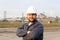 Portrait of engineer in helmet standing in construction site background.