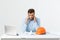 Portrait of engineer stress holding his head with hand sitting at the table and feel headache in the office on