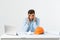 Portrait of engineer stress holding his head with hand sitting at the table and feel headache in the office on