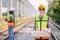 Portrait engineer women on railway tracks construction site with blueprint roll working project manager in suburb transportation
