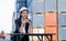 Portrait of engineer worker of factory technician with Chinese woman style sit in front of cargo container crane in workplace area