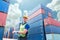 Portrait of engineering man wearing uniform safety suit and helmet in industrial containers for shipping logistics.