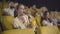 Portrait of engrossed Caucasian woman watching exciting film in cinema and eating popcorn. Angle view of absorbed female