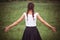 Portrait of enjoying woman raising her hands in the field