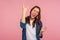 Portrait of enthusiastic overjoyed girl in checkered shirt showing rock and roll gesture and yelling