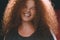 Portrait of ethnic redhead curly-haired woman with freckles.