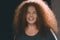 Portrait of ethnic redhead curly-haired woman with freckles.