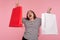 Portrait of euphoric thrilled enthusiastic woman in striped sweatshirt screaming, expressing great joy and raising shopping bags