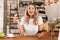 Portrait of european blond woman using smartphone and plastic credit card while sitting in cozy cafe indoor