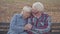 Portrait of a European retired couple sitting on the bench and talking. Mature husband calming down his beautiful senior