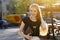 Portrait of european smiling woman with laptop walking on city street