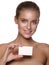 Portrait of an european young smiling girl with healthy perfect smooth skin, who is holding a business visiting card