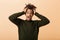 Portrait of excited african american man yelling and grabbing head, isolated over beige background