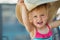 Portrait of excited baby in beach hat