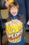 Portrait Of Excited Boy Offering Popcorn Bucket At