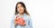 Portrait of an excited cute teen black woman holding opened present box isolated over white background