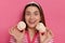 Portrait of excited delighted woman wearing striped t shirt posing isolated over pink background, looking at camera with