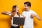 Portrait of excited happy man and woman holding and pointing fin