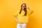 Portrait of excited happy young woman in fur sweater and heart orange glasses showing victory sign isolated on bright