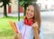 Portrait of excited laughing teenager girl with raising arm celebrating outdoors