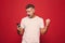 Portrait of an excited man standing over red background