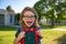 Portrait of excited pupil with backpack near school outdoors.