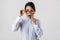 Portrait of excited secretary woman 30s wearing eyeglasses standing in the office, isolated over white background