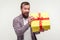 Portrait of excited surprised bearded man unpacking present box and looking happily amazed at camera. white background