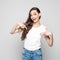 Portrait of excited teenager girl pointing at white t-shirt