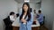 Portrait of excited young Asian woman pleading looking at camera with blurred coworkers at conference table working at