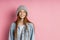 Portrait of excited young woman dressed denim jacket and knitted hat