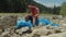 Portrait of exhausted black man ecologist relaxing on garbage bag after cleanup in mountains