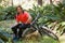 Portrait of exhausted male mountain biker relaxing on a tree trunk in the forest