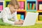 Portrait of exited boy using laptop while lying on floor