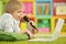 Portrait of exited boy using laptop while lying on floor