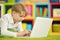 Portrait of exited boy using laptop while lying on floor