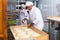 Portrait of experienced professional baker during daily work in kitchen of small bakeshop