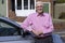 Portrait Of Experienced Senior Male Driver Standing Next To Car