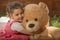 Portrait of expressive little girl hugging her toy bear