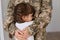 Portrait of faceless military woman wearing camouflage uniform hugging her little cute daughter, mother missing her kid very much