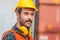 Portrait of factory worker man in hard hat and safety vest, Engineer man with containers box background at cargo