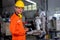 Portrait of factory worker man with holding tablet stand with smiling in front of industrial robotic machine in workplace area.