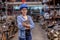 Portrait of factory worker woman with blue hardhat holds tablet and stand in automotive parts workplace area and look to camera.