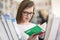 Portrait of famale student selecting book to read in library