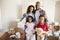 Portrait Of Family Carrying Boxes Into New Home On Moving Day