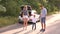 Portrait of a family with a child near a car with an open trunk on an empty road