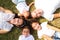 Portrait of a family of five, father, mother and children lying on the fresh grass looking at the camera. It is an example of a