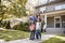 Portrait Of Family Holding Keys To New Home On Moving In Day