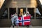 Portrait of family with kids outside cabin house holding Norway flags. Scandinavian culture, norwegian people