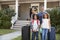 Portrait Of Family With Luggage Leaving House For Vacation